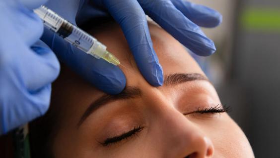 Person receiving cosmetic injection in forehead area