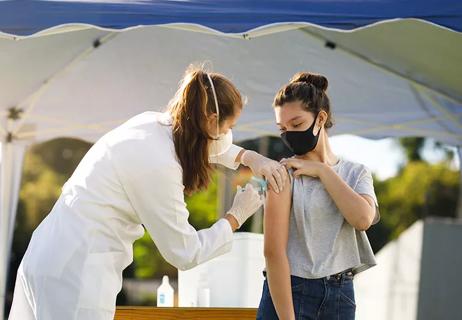 doctor giving teen girl covid vaccination
