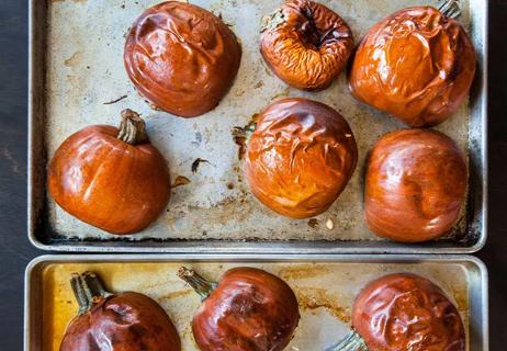 Roasted pumpkins are split in half on a baking tray fresh out of the oven.