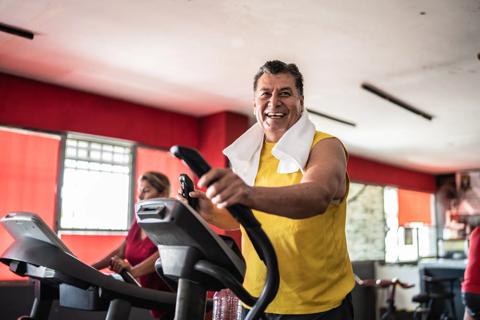 Happy person using an elliptical machine at a gym