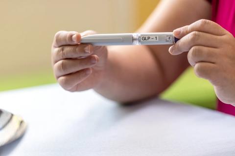 Person holding GLP-1 injectable