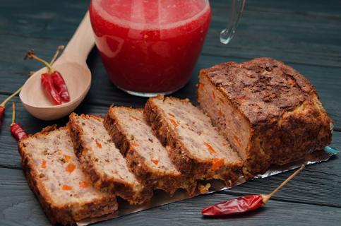 Mexican turkey meatloaf, sliced, with hot red peppers around loaf