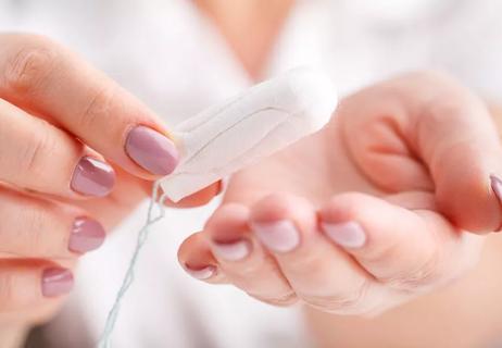 Woman's hands holding clean cotton tampon