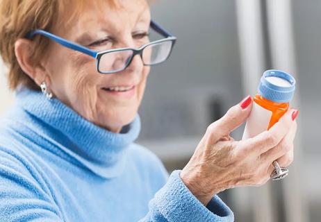 Woman reading her medication bottle