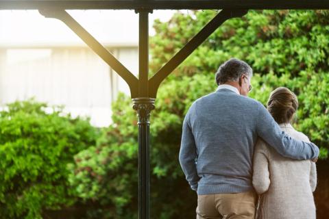 A senior couple embracing with their backs facing the camera