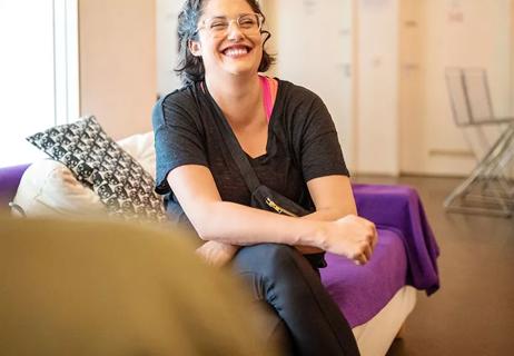 Woman sitting on couch and laughing with friends.