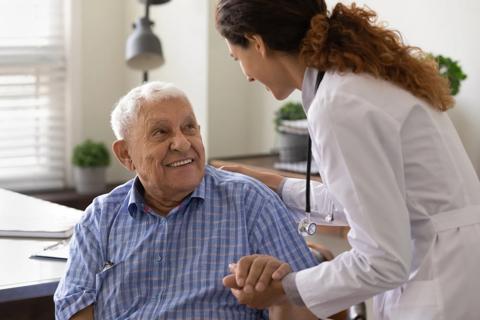 Healthcare provider talking with older person, hand on their shoulder
