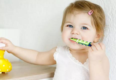 baby girl brushing first teeth
