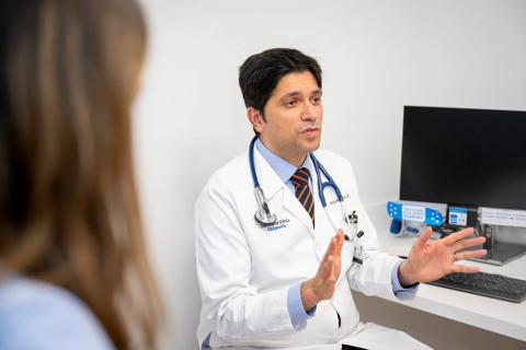 Dr. Amdani talks to patients in a clinic room