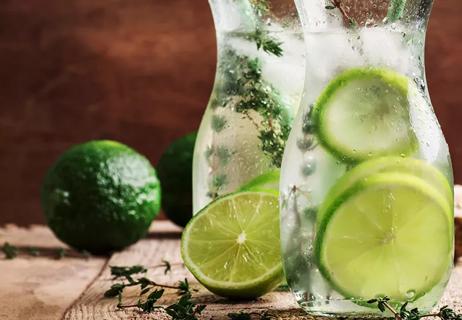 Close up of lime slices floating in carafes filled with water.