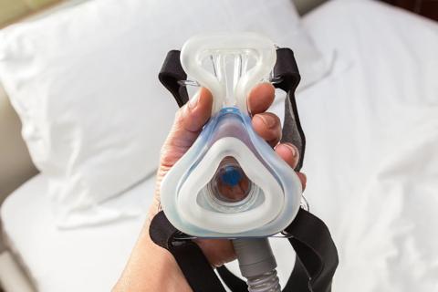 Hand holding CPAP mask and attachment