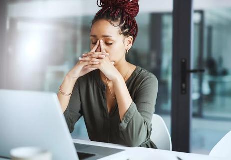 woman taking a deep breath at work to relieve stress