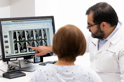 Physician speaking with patient by computer