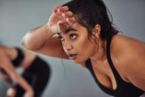 Female sweating and wiping brow during workout