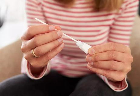 Person took swab test and is inserting swab back into tube.