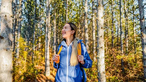Happy caucasian woman hiking in forest