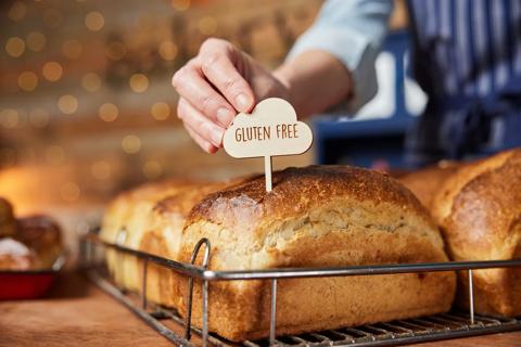 Baker placing "gluten free" tag into loaf of bread