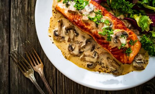 Plated salmon marsala, with leafy greens