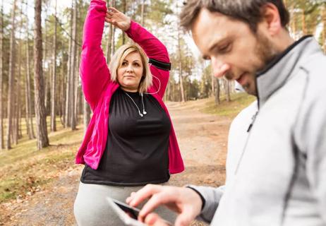 Woman stretching before going on a walk with her husband