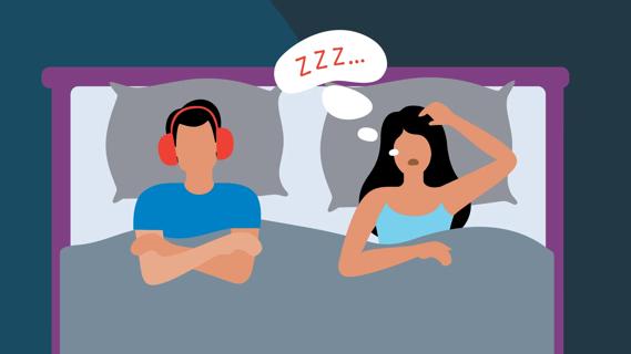 Couple in bed with one partner snoring and the other in noise-reducing headphones