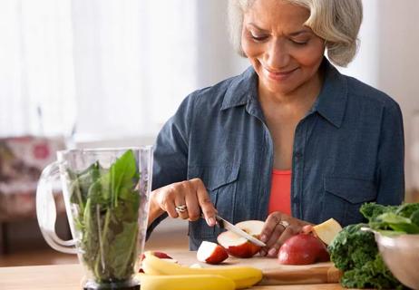 Older woman prepares healthy drink with immune boosting ingredients.