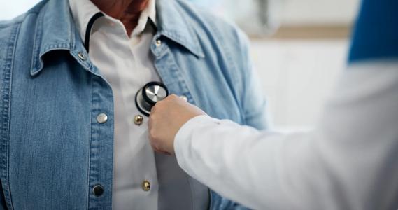 Healthcare provider listening to patient's heart with stethoscope