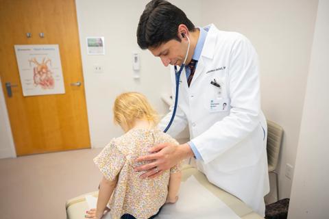 Dr. Amdani listens to young patient's heart