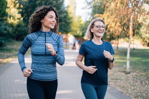 Two women briskly walking in a park