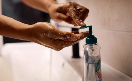 Hand pumping liquid soap from bottle onto other hand