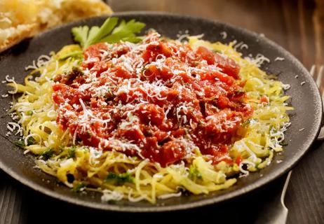 Wide bowl of spaghetti squash with tomato sauce and cheese