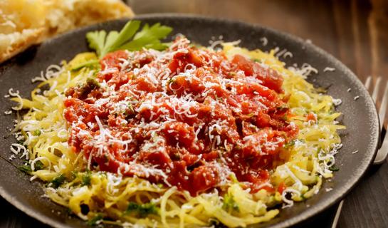 Wide bowl of spaghetti squash with tomato sauce and cheese