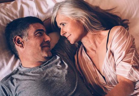 Romantic elderly couple relaxing together and lying down in bed