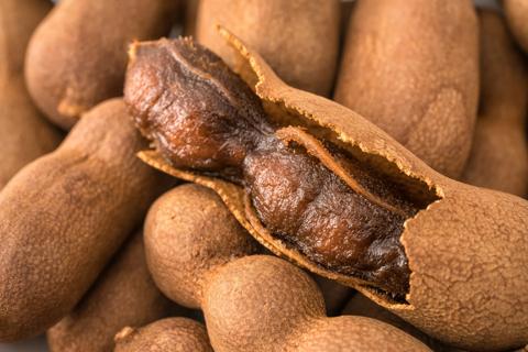 Partially peeled and whole tamarind fruits