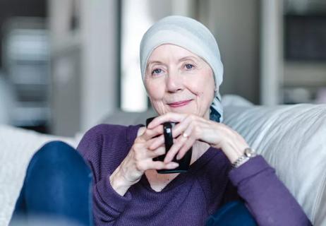 woman with cancer at home sipping tea