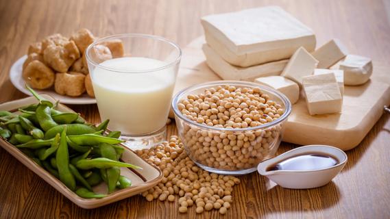 Assortment of soy foods on table, like edamame, soy milk, tofu and soy sauce