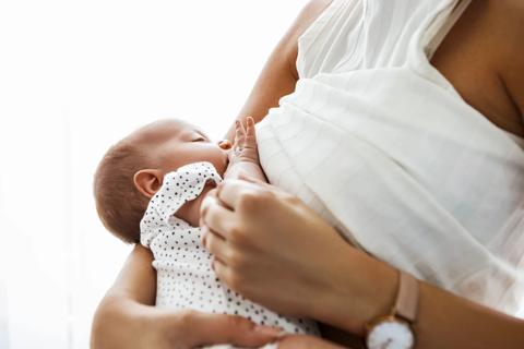 Parent holds breastfeeding infant