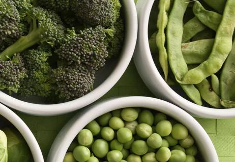 Three bowls of broccoli, green beans and peas.