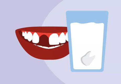 Mouth showing missing tooth and glass of milk with saved tooth immersed in the liquid.