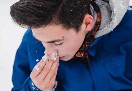 boy with nosebleed in winter