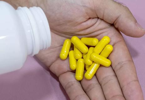 Closeup of a person pouring berberine supplements into their hand.