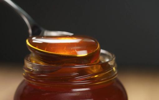 Spoonful of honey from a honey jar