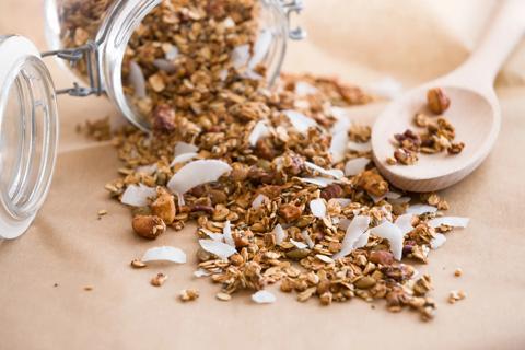 Almond and coconut trail mix poured from jar onto table