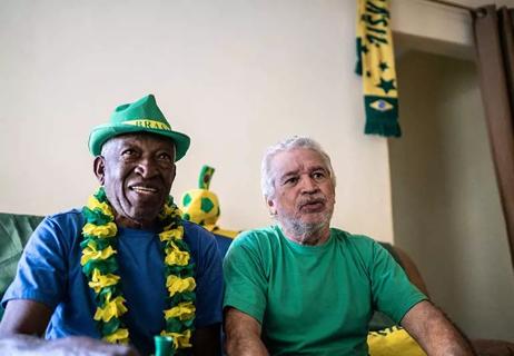 Two older people watching a sports event.