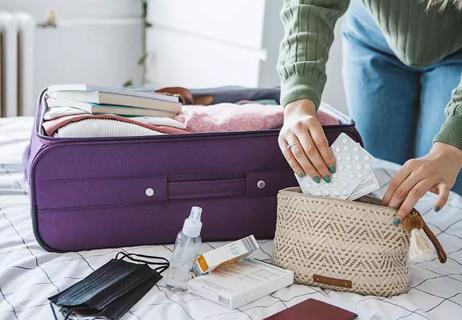 person packing medication for suitcase