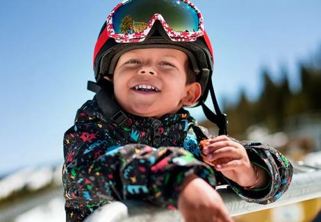 little boy taking a cookie break from snowboarding