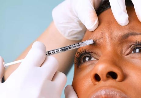 Closeup of person recieving baby botox injection in forehead.