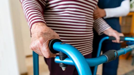 Geriatric patient with walker, caregiver