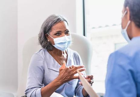 Middle-aged Black woman talks with doctor