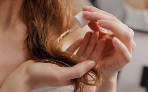 Person applying oil to the ends of their hair