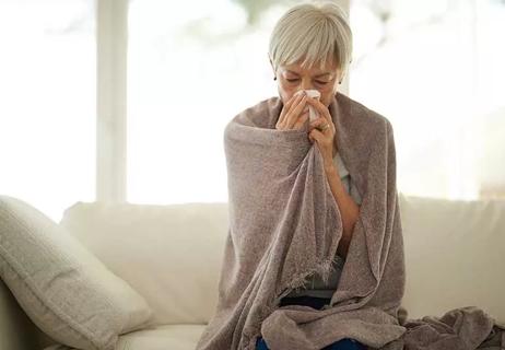 person blowing nose on sofa